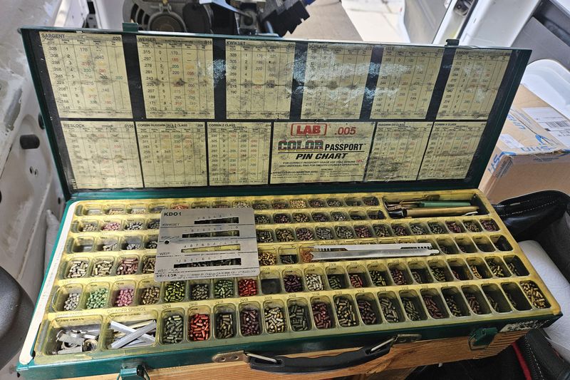 A professional pinning kit with hundreds of color-coded pins and a pin chart, open on the bench.